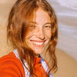 Χαρούμενη κοπέλα που κοιτά τον φακό ευτυχισμένη