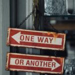 Επιγραφή επάνω σε πόρτα που αναγράφει με βέλη Από εδώ ή Από Εκεί