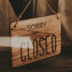 Γυάλινη πόρτα με ταμπέλα επιγραφή Sorry Closed που συμβολίζει προσωπική ανάπτυξη