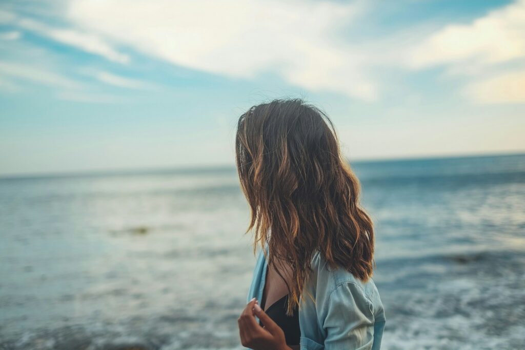Νεαρό κορίτσι που ατενίζει την θάλασσα σαν να κοιτάζει το παρελθόν της