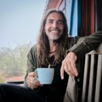 Ευδιάθετος άνδρας γύρω στα 50 απολαμβάνει τον καφέ του στην φύση